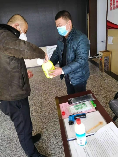 七台河公司东风矿矿党委副书记王占寒在督导检查防疫工作的同时为单位提供测温仪、消毒液、喷壶等防护用品。。。。。。图为王占寒（左）正与党员对办公场所进行消毒。。。。。。（于秀娟摄）